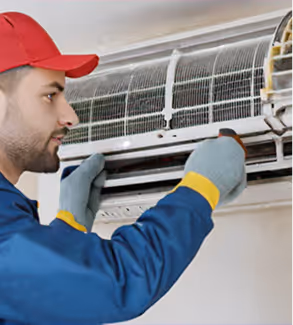 Technician servicing an air conditioning unit with tools and gauges.