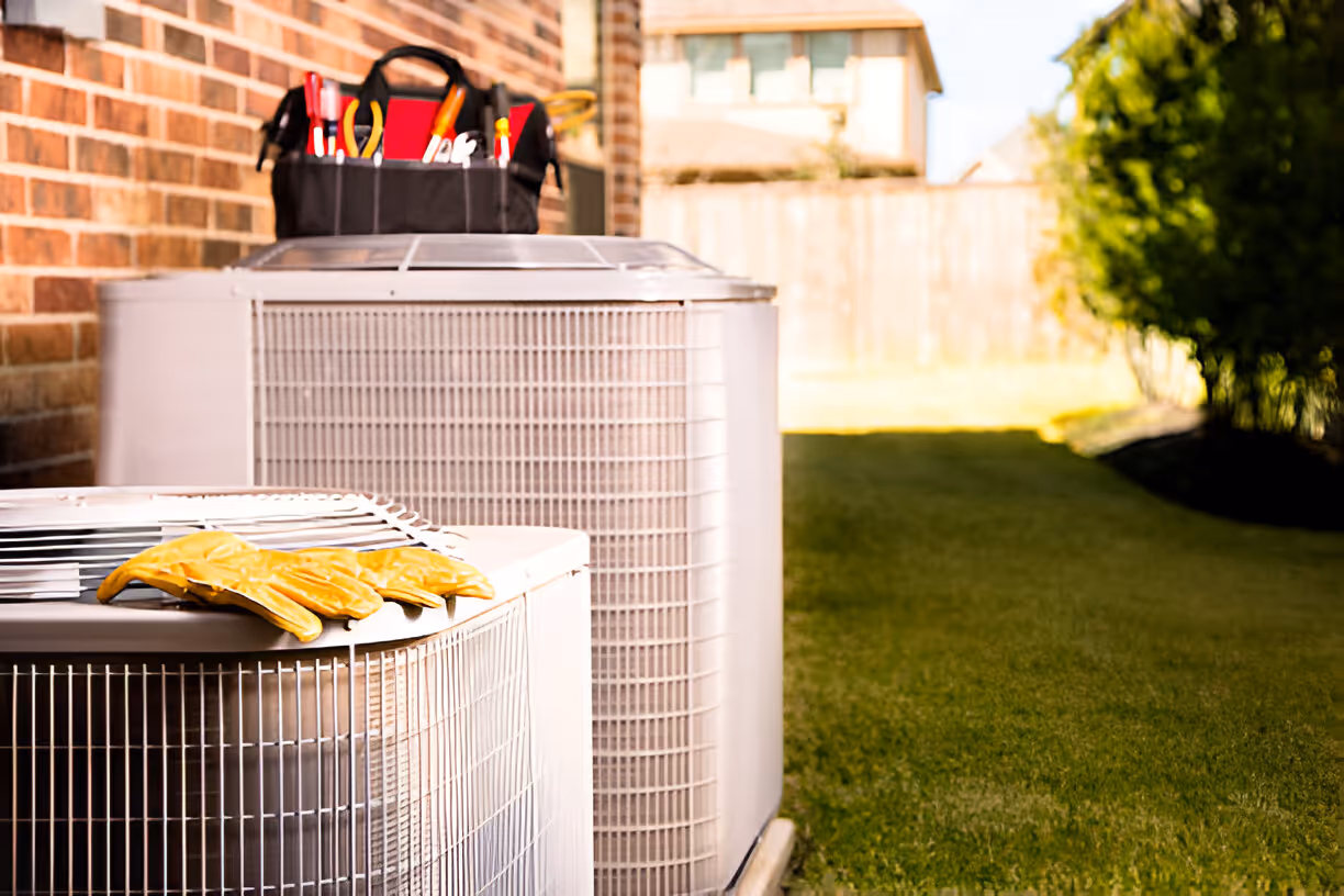 Air conditioning units next to a workshop with tools and gloves, ready for maintenance and repair.